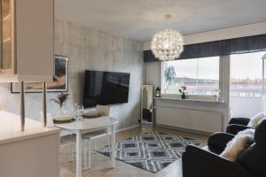 uma sala de estar com um sofá e uma televisão em Penthouse with Sauna - King Size Bed - Free WiFi! em Rovaniemi