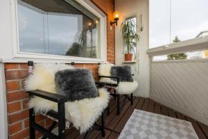 um alpendre com três cadeiras com pêlo falso em Penthouse with Sauna - King Size Bed - Free WiFi! em Rovaniemi