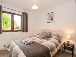 Schlafzimmer mit einem Bett und einem Fenster in der Unterkunft Quarry Cottage in Cheddar