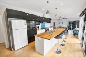 cocina con nevera blanca y encimera de madera en The Green House en Paynesville