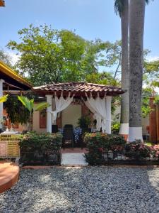 un patio trasero con pérgola, mesa y sillas en Hotel Boutique Los Gentiles, en Santa Fe de Antioquia