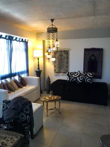 ein Wohnzimmer mit schwarzen und weißen Möbeln und einem Kronleuchter in der Unterkunft Suite Dubai salta in Salta