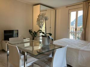 聖佩萊格里諾溫泉的住宿－Al ponte vecchio，一间设有玻璃桌和白色椅子的用餐室