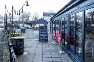 una tienda con letreros al lado de una calle en Pillo Rooms - Spacious Cosy 2 Bedroom House by Bridgewater Canal en Mánchester