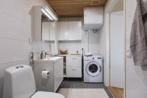 a white bathroom with a washing machine and a washer at Quality Suite with Sauna - 2 Bedrooms - BRAND NEW 2022 in Rovaniemi