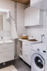 a white kitchen with a washing machine and a sink at Quality Suite with Sauna - 2 Bedrooms - BRAND NEW 2022 in Rovaniemi +12 photos