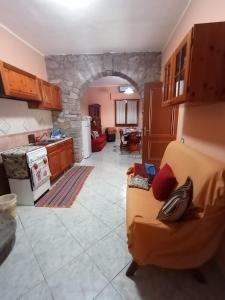 ein Wohnzimmer mit einem Sofa und einer Küche in der Unterkunft Fontana Nuova in Sardara