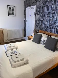 een slaapkamer met een groot wit bed met een muur bij Willow Dene in Scarborough