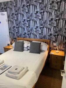 een slaapkamer met een bed met een muur bedekt met geld bij Willow Dene in Scarborough