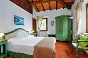a bedroom with a bed and a green cabinet at Agriturismo Pimpinnacolo in Porto Ercole