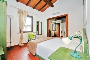 a bedroom with a bed and a table with a lamp at Agriturismo Pimpinnacolo in Porto Ercole