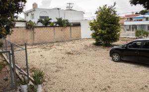 a black car parked in a gravel parking lot at Departamento Orellana 1 in Chetumal