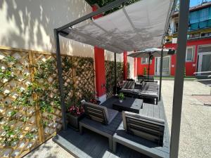 a patio with chairs and an umbrella and a fence at Hostel Turin Metro Young in Turin