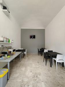 a dining room with black tables and white chairs at Hostel Turin Metro Young in Turin