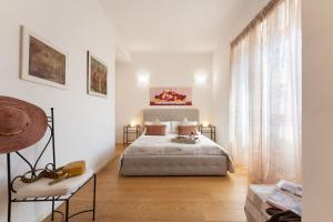una camera bianca con un letto e una grande finestra di Santa Maria Novella - Flo Apartments a Firenze