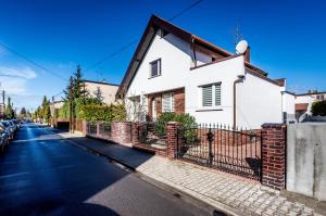 una casa blanca con una valla al lado de una calle en Villa House Poznań * SAUNA *, en Poznan