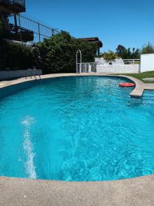 a large pool with blue water in a yard at Departamento Frente al Mar in Concón