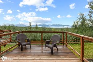 2 sillas sentadas en una terraza de madera con vistas en Tranquil Stay at Settlers Bay, Newly Furnished!, en Wasilla