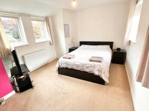 Una cama o camas en una habitación de Cosy House With Parking Near Lark Lane & City Cent