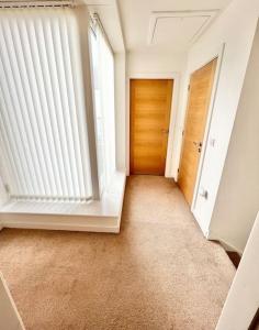 an empty hallway with a door and a window at Cosy House With Parking Near Lark Lane & City Cent in Liverpool