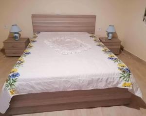 a bedroom with a large bed with two night stands at Angela's place - Stomio residence near the sea in Stómion