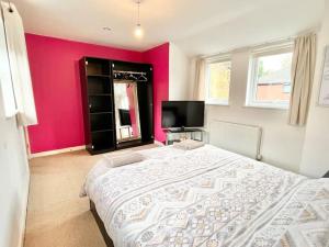 a bedroom with a large bed and a tv at Cosy House With Parking Near Lark Lane & City Cent in Liverpool