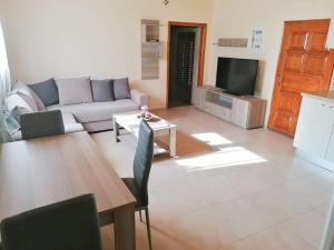 a living room with a couch and a table at Angela's place - Stomio residence near the sea in Stómion