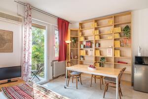 a dining room with a table and bookshelves at Prato della Valle Red & Blu Studios in Padova