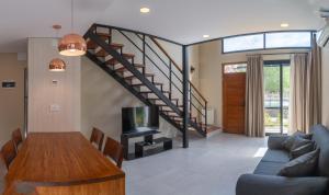 sala de estar con mesa de madera y escalera en El Nogal Apart Hotel en Villa General Belgrano