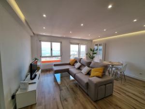 un soggiorno con divano e tavolo di C01A01 Apartamento Moderno con vistas al mar a Santander