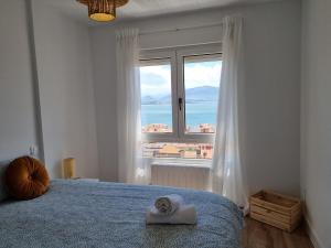 a bedroom with a bed and a large window at C01A01 Apartamento Moderno con vistas al mar in Santander