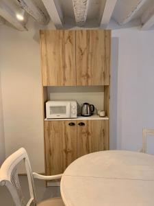 una cocina con mesa y microondas en un armario en Cal Torrentó Apartaments, en Balaguer