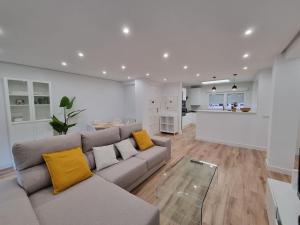 salon z szarą kanapą i żółtymi poduszkami w obiekcie C01A01 Apartamento Moderno con vistas al mar w mieście Santander