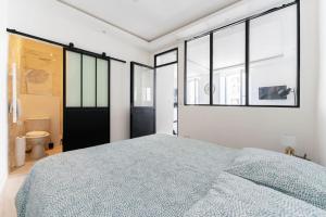 ein Schlafzimmer mit einem großen Bett und einigen Fenstern in der Unterkunft Au cœur du Panier, Confort à 2 pas du Port ! in Marseille