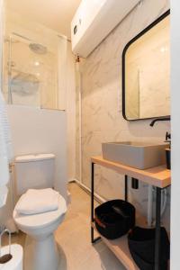 een badkamer met een wit toilet en een wastafel bij Au cœur du Panier, Confort à 2 pas du Port ! in Marseille