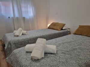 dwa łóżka z ręcznikami na nich w pokoju w obiekcie C01A01 Apartamento Moderno con vistas al mar w mieście Santander