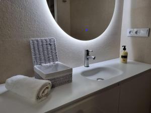 w łazience znajduje się umywalka z lustrem i ręcznik. w obiekcie C01A01 Apartamento Moderno con vistas al mar w mieście Santander +37 zdjęć