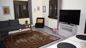 a living room with a couch and a flat screen tv at Elassona Comfort Home in Elassona