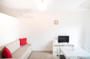 a white living room with a white couch and red pillows at DiMora RIccaFrida - Luxury Home - in Prato +8 photos