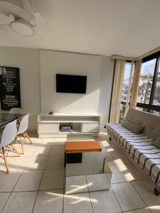 ein Wohnzimmer mit einem Sofa und einem TV in der Unterkunft Apartamento no Guarujá a 400 mts da praia in Guarujá