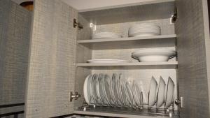 a kitchen with white plates and bowls on shelves at Elassona Comfort Home in Elassona