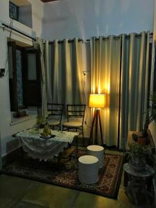 a living room with a table and a lamp at Sanjana's stay in Udaipur +36 photos