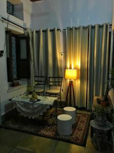 a living room with a table and a lamp at Sanjana's stay in Udaipur