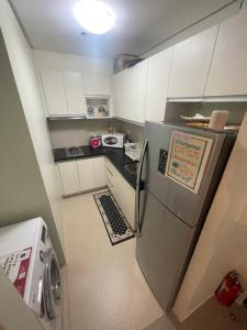 eine kleine Küche mit weißen Schränken und einem Kühlschrank in der Unterkunft Magerife’s Home in Boracay