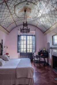 a bedroom with a large bed and a piano at Monasterio de San Francisco in Palma del Río