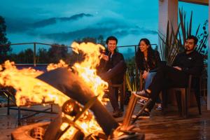 een groep mensen die rond een vuur zitten bij Viajero Salento Hostel in Salento