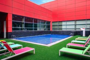 ein Gebäude mit einem Pool mit Liegestühlen in der Unterkunft Royal Plaza on Scotts in Singapur