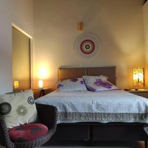 a bedroom with a bed with a chair and a clock at Pousada Familiar Morada Lua Nova in Florianópolis