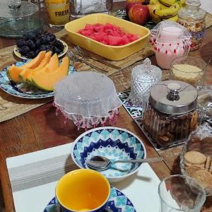 a table with bowls of fruit and plates of food at Pousada Familiar Morada Lua Nova in Florianópolis