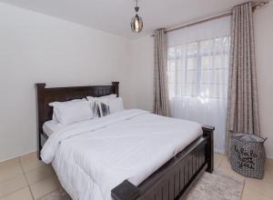 a bedroom with a large bed and a window at Athi Luxury Suites in Athi River